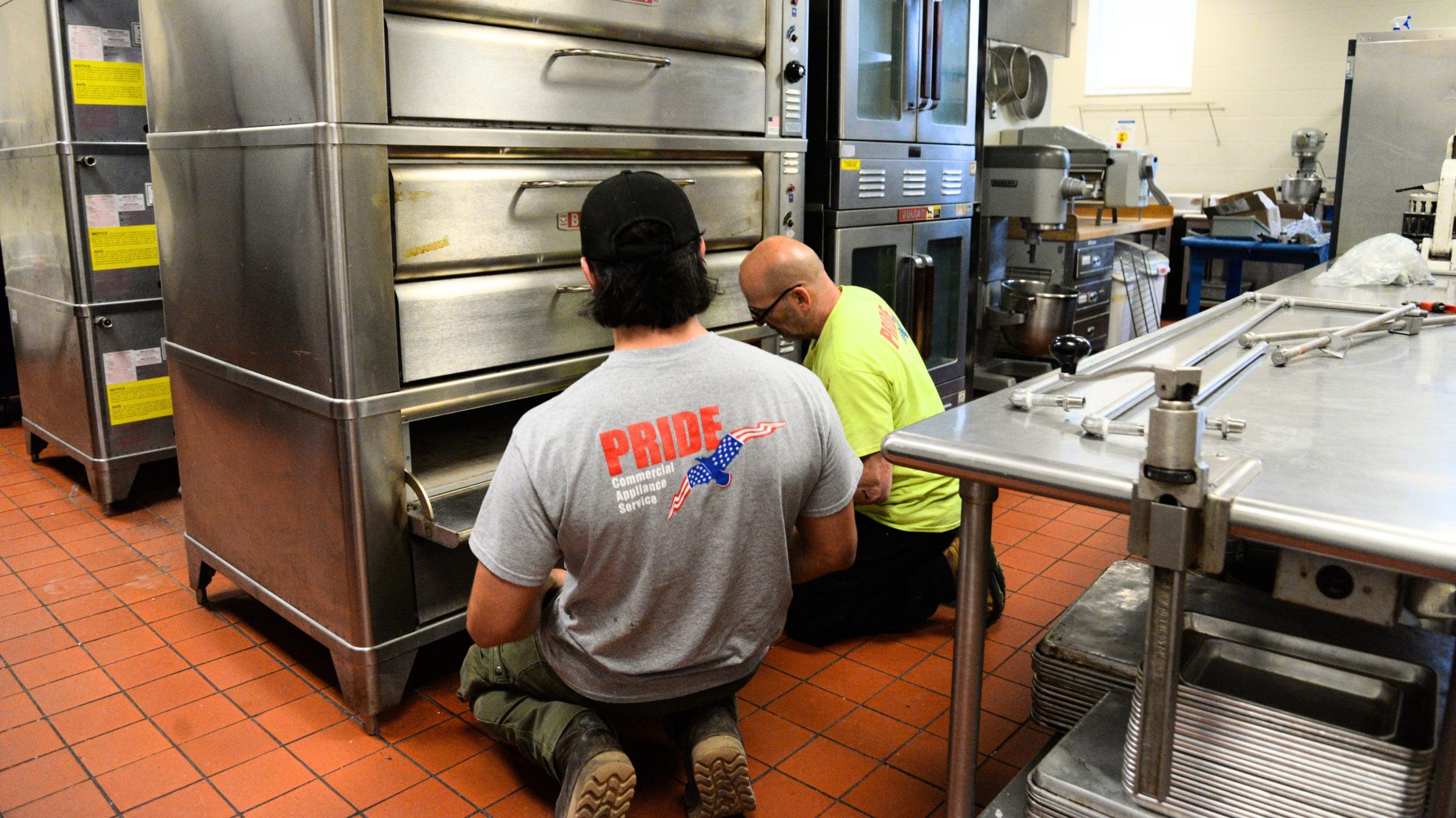 Two technician perform repairs on a blodgett oven