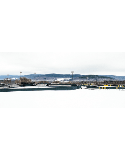 Cooperstown Dreams Park in winter and snow-covered fields and mountains in the background.