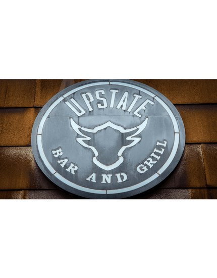 Upstate Bar and grill logo in a silver disc with a bulls head outline in the middle