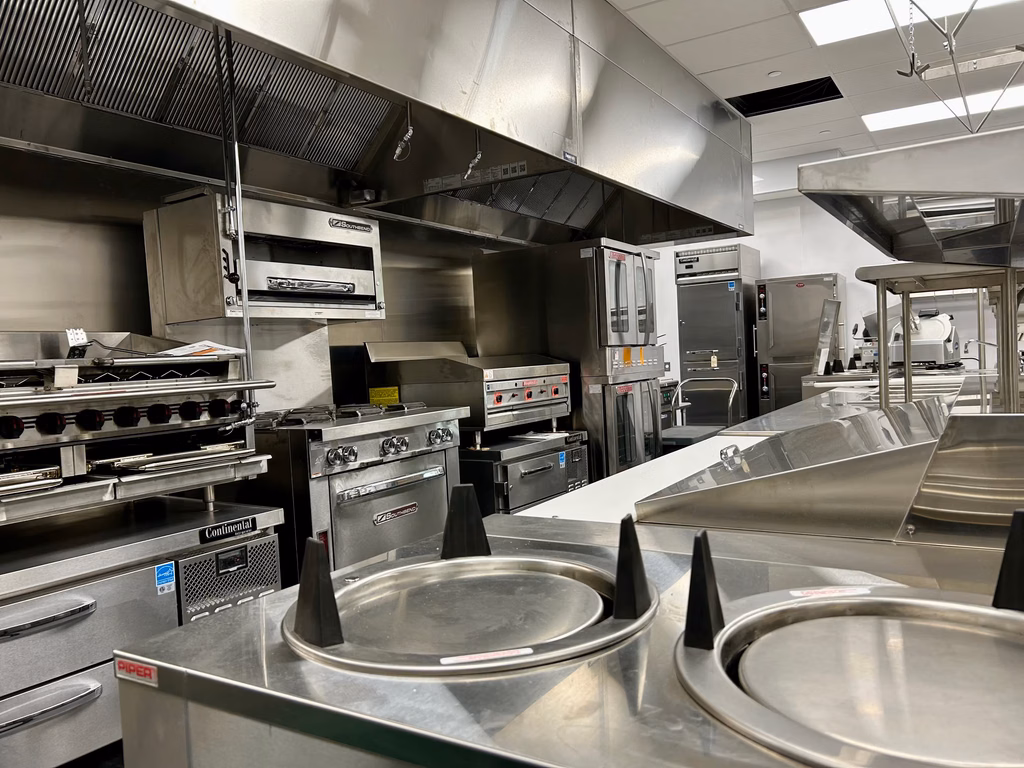 Commercial Kitchen line featuring a several different types of equipment for cooking and prep.
