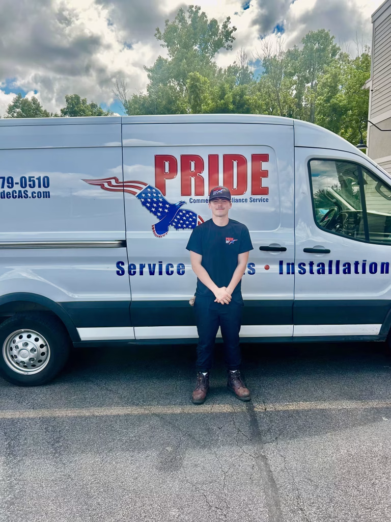Blake stands in front of a pridecas van on his first day as a full time technician